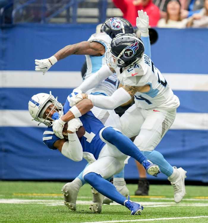 Indianapolis Colts wide receiver Josh Downs (1) comes down with the ball while being guarded by Tennessee Titans cornerback Kristian Fulton (26) and Tennessee Titans cornerback Elijah Molden (24) on Sunday, Oct. 8, 2023, during a game against the Tennessee Titans at Lucas Oil Stadium in Indianapolis.